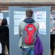 Student with a backpack observing a research poster