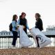 Two students speaking with Kelly Coate near the Palace Pier during a beach clean