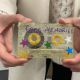 Two hands holding a cassette tape decorated with glitter, stars and the text 'core memories'