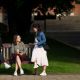 Three students talking on a bench by Library Square