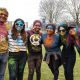 Students posing for a photo covered in coloured paint from the Holi festival