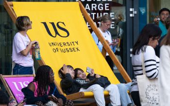 Students taking selfies in a giant University of Sussex deckchair