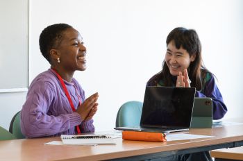 two students smiling in classroom