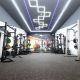 A photo of the new University of Sussex gym located in the Sports Centre. Photo shows gym equipment and colourful lighting.