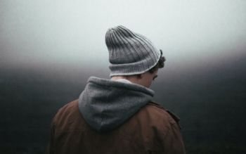 Young man facing away on a grey background