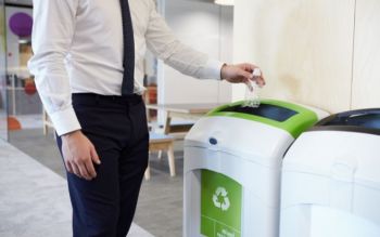 White man putting plastic bottle in recycling bin