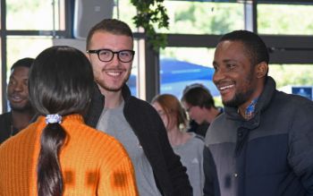 Three students chatting at a party