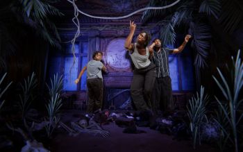 Three black actors in a computer generated room that looks like a hunted house