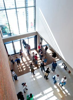 Students waiting before a lecture beneath large windows