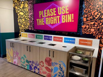 One of the new recycling banks in Eat Central, with a screen behind saying 'Use the right bin!'