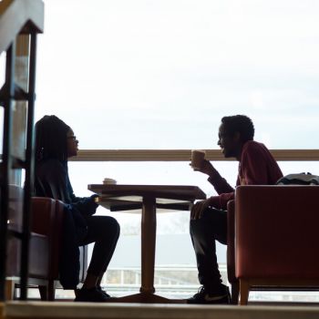 Two students chat over coffee