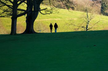 Two people walk in Stanmer park