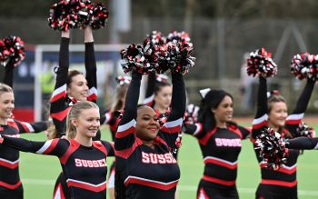 A group of  Sussex cheerleaders, waving pom-poms at the Varsity match
