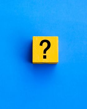 A question mark on a yellow scrabble tile on a vivid blue background