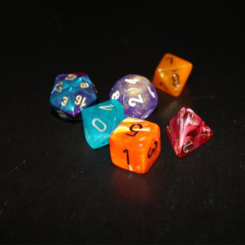 Colourful die of different being rolled on black background