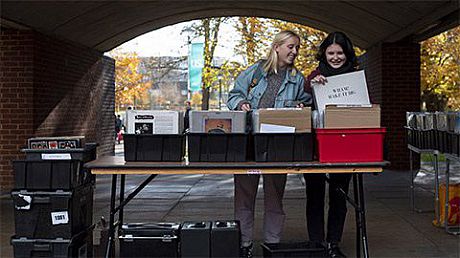 Two students browse vinyl records in the quad of Falmer House