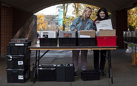 Two students browse vinyl records in the quad of Falmer House
