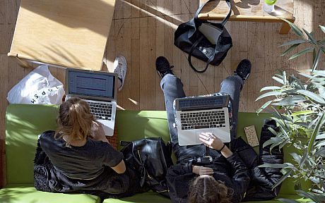 Two students working on laptops, from above