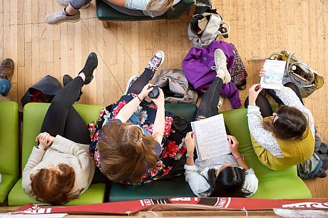 Students sitting on comfortable chairs in the common room, seen from above