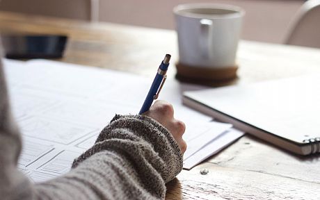 Hand working on paper at desk