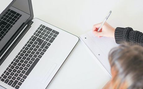 Woman studying with laptop and notebook