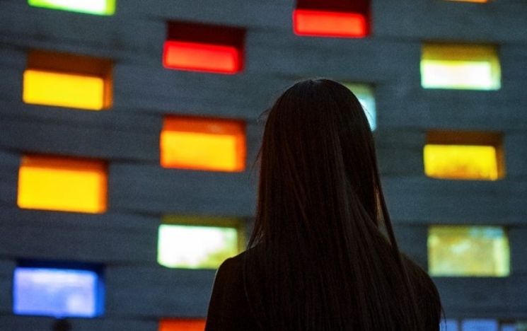 Student observing the stained glass windows in the Meeting House