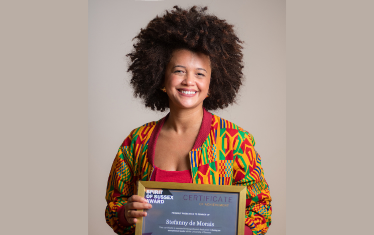 Head shot of Stefanny holding her Spirit of Sussex Award certificate.