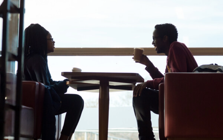 Two students sitting at a table having coffee