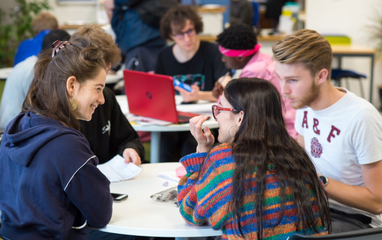 Students connect with one another around a table