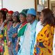 Line of twelve men and women dressed in traditional Nigerian clothes