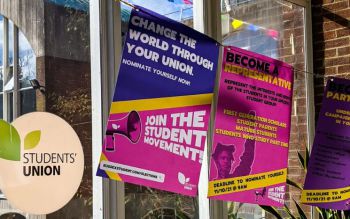 Colourful posters encouraging students to join the student movement hang in front of a large window