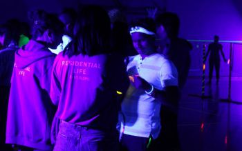 Students glowing under UV light in the Sports Centre