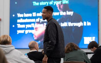 Young black man walking among the audience he's presenting to
