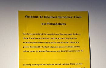 A yellow sign welcoming people to the exhibition