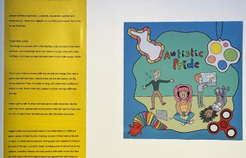 A photograph of an "Autistic Pride" artwork alongside a yellow sign with its exhibition description
